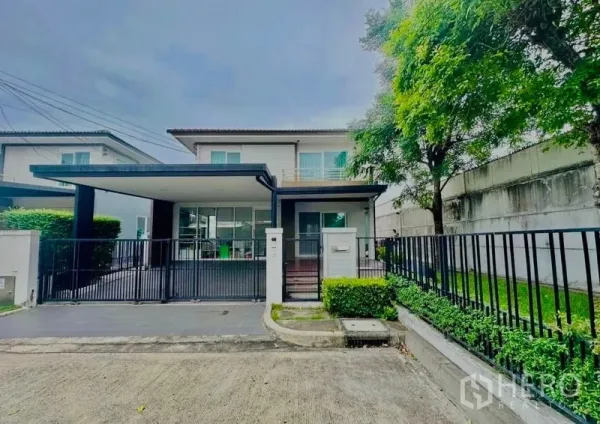 独立式住宅 出售在Prawet, Bangkok - 现代两层住宅正立面，金属围栏与宽敞车道。