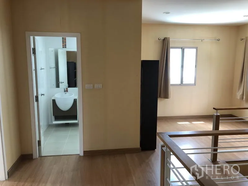 独立式住宅 出租在Suan Luang, Bangkok - 二楼走廊，通向浴室，采光良好与金属楼梯扶手