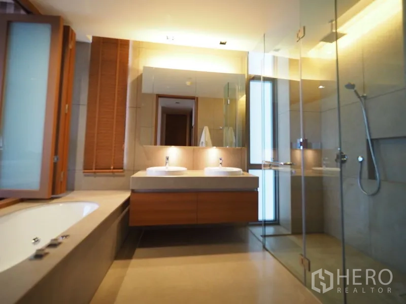 Condominium for rent in Sathon, Bangkok - Modern bathroom with double vanity, glass shower and soaking tub.