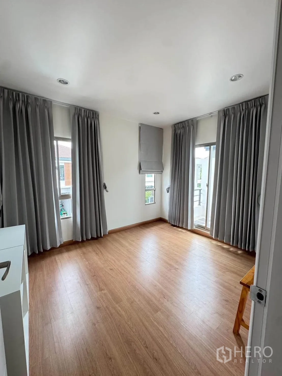 半独立式住宅 for rent or sale in Suan Luang, Bangkok - 采光充足的卧室，木地板与灰色窗帘，多扇窗户。
