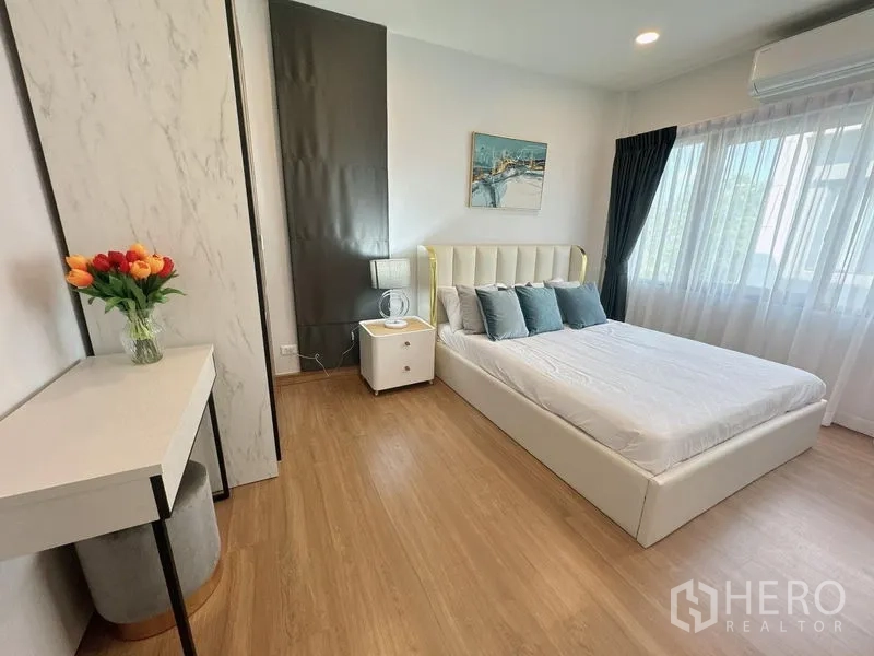 Detached House for rent or sale in Bang Phli, Samut Prakan - Sunny bedroom with white bed frame, marble-effect wardrobe and bedside table.