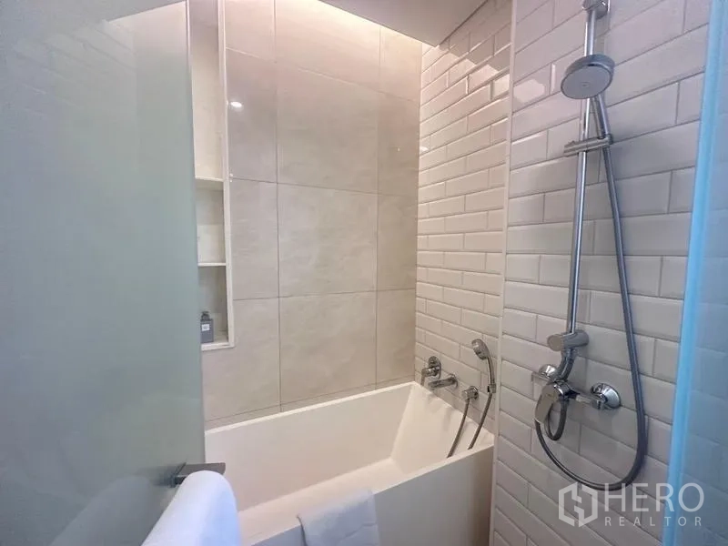 Condominium for rent - Bathtub and shower combo with white subway tiles and handheld shower.