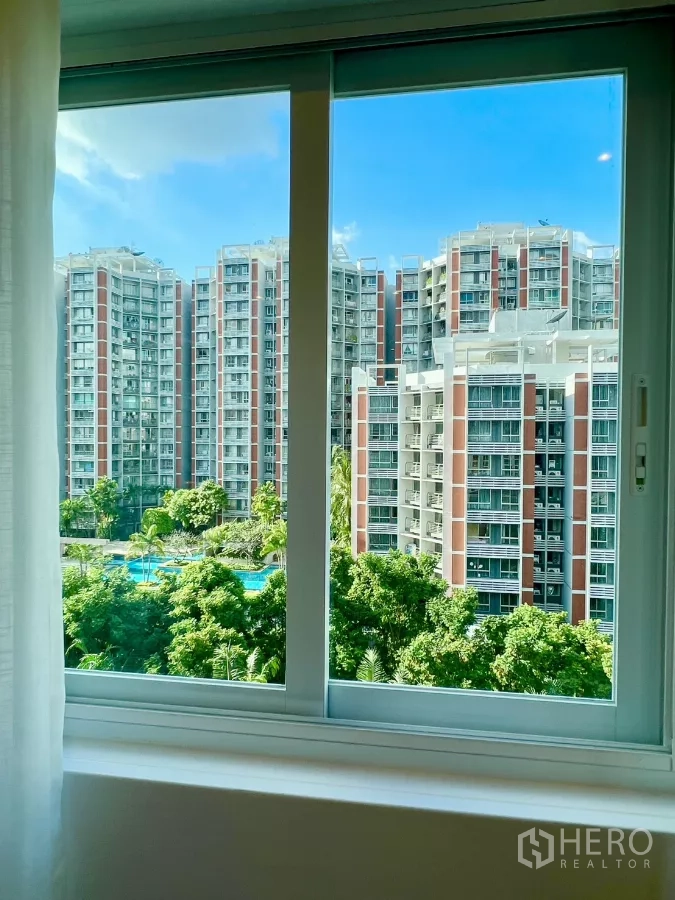 公寓 出售在Yan Nawa, Bangkok - 窗外可见邻近公寓楼与树梢上的泳池。