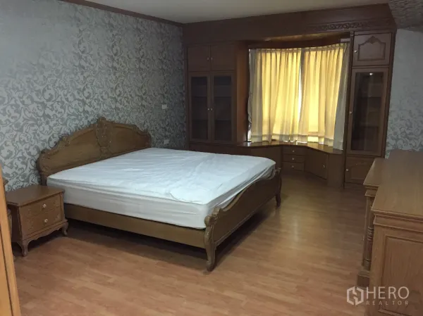 คอนโด ให้เช่าในWatthana, Bangkok - ห้องนอนใหญ่เตียงไม้ วอลเปเปอร์ลายคลาสสิก ตู้บิวท์อินรอบหน้าต่างทรงเบย์ และพื้นที่เก็บของมากมาย