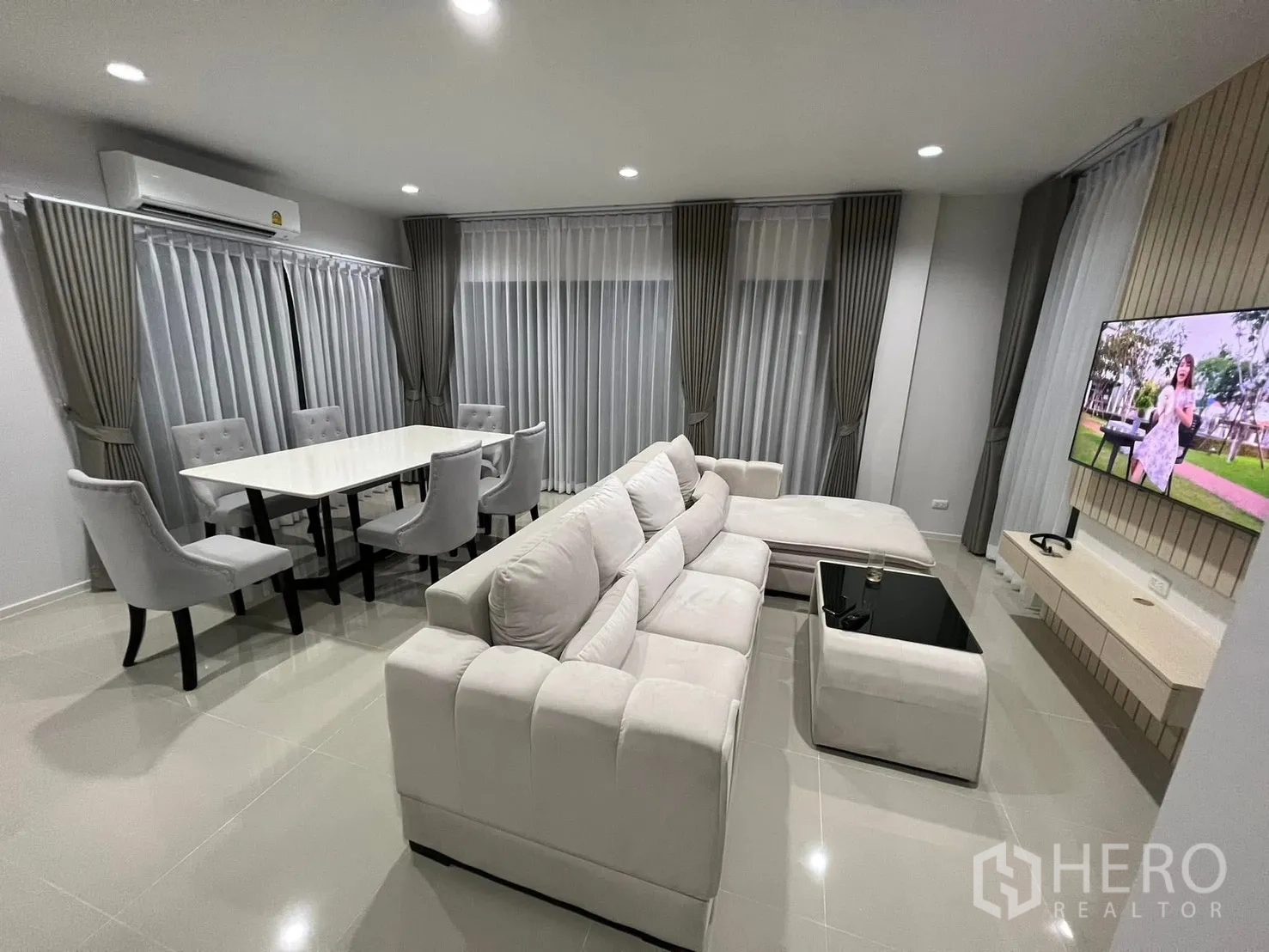 บ้านแฝด for rent in Saphan Sung, Bangkok - ห้องนั่งเล่นและรับประทานอาหารแบบโอเพนแพลน โซฟาตัวแอล ชุดโต๊ะทานข้าว และม่านยาว