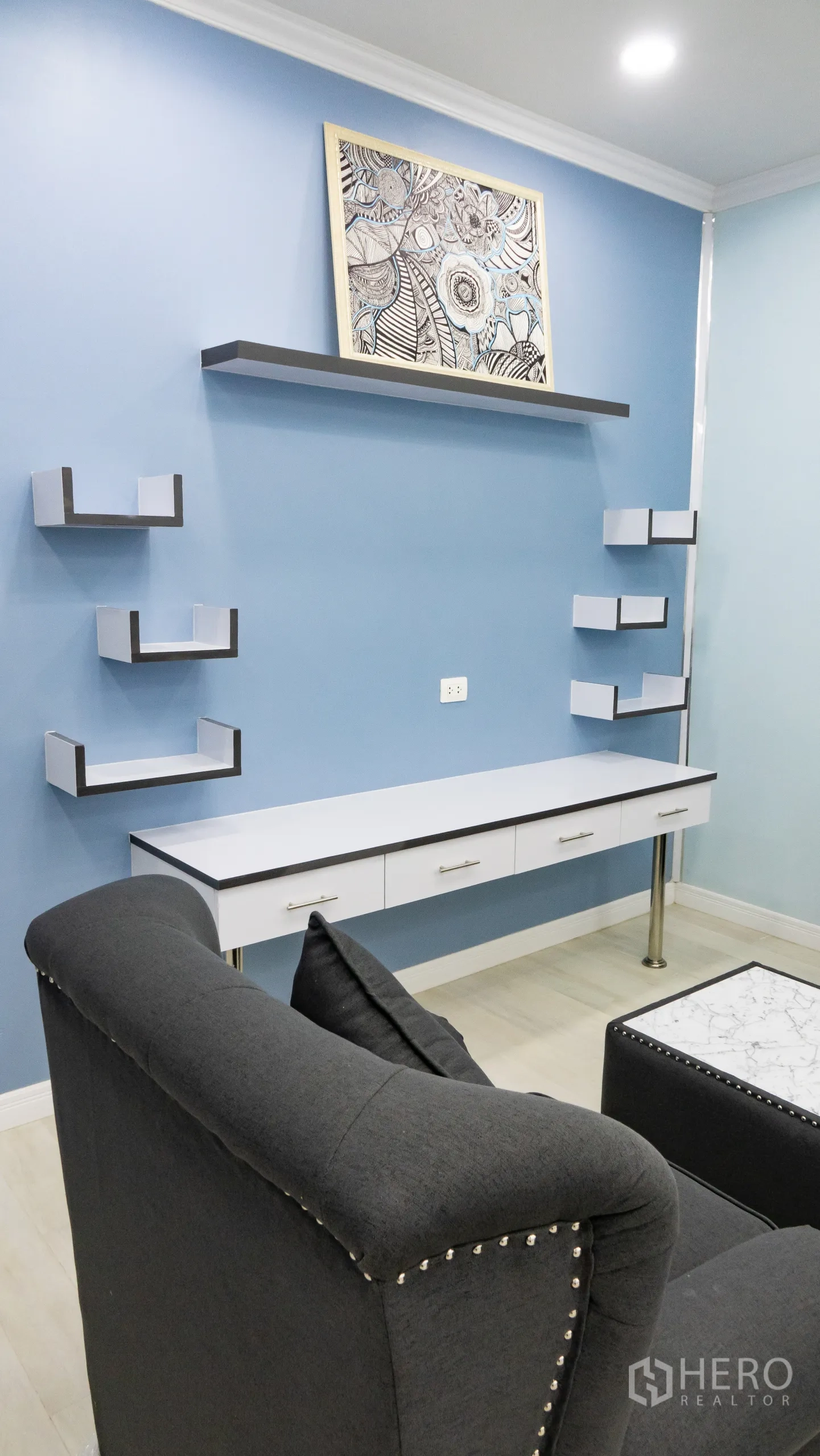 Condominium for rent or sale in Khlong Toei, Bangkok - Lounge feature wall with floating shelves and a long built‑in desk.