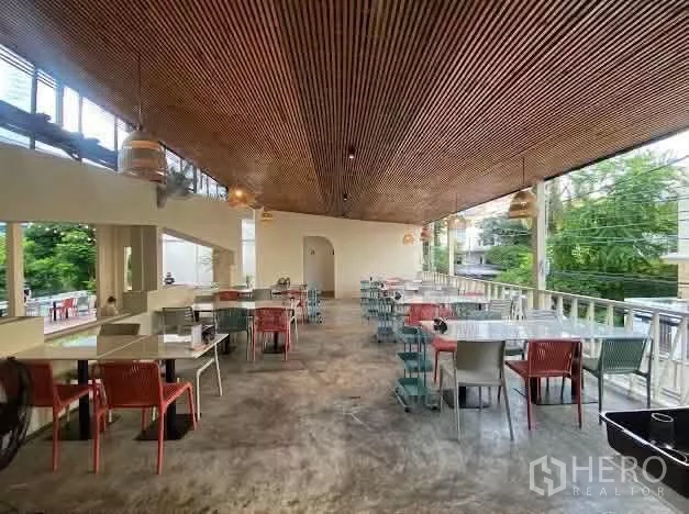零售空间 出租在Sathon, Bangkok - 二层半开放用餐区，木格栅吊顶，多组餐桌临近绿意。