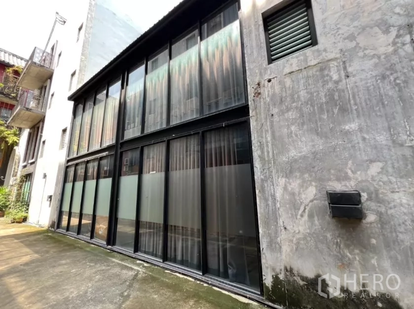 带办公室的家 出租在Pathum Wan, Bangkok - 四层家用办公楼外立面，黑色框架落地玻璃。