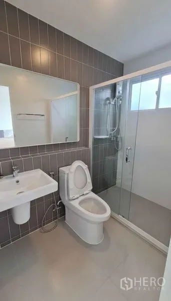 Townhouse for rent in Prawet, Bangkok - Modern bathroom with vanity, toilet and a glass-enclosed shower.