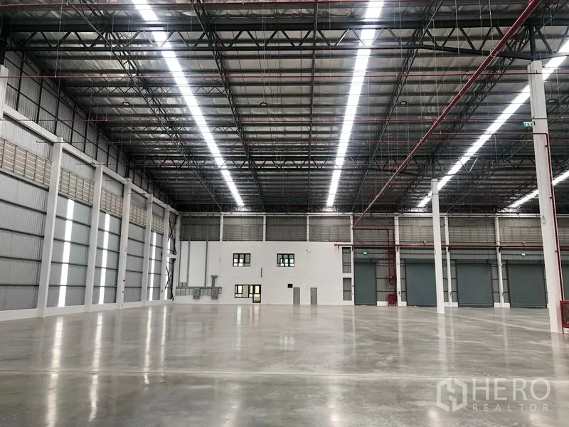 Factory for rent in Wang Noi, Phra Nakhon Si Ayutthaya - Factory interior featuring a white office block, electrical panels, and roller doors.