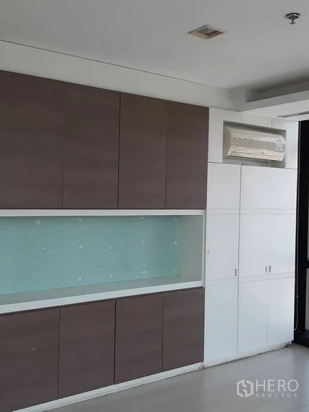Office Space for rent in Bang Rak, Bangkok - Wall of built-in cabinets with display niche and split-type air conditioner.