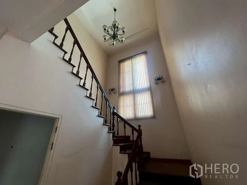 Detached House for rent in Watthana, Bangkok - Staircase with wooden handrail, tall window and chandelier.