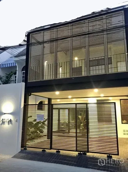 ทาวน์เฮาส์ ให้เช่าในKhlong Toei, Bangkok - ด้านหน้าทาวน์เฮ้าส์สองชั้นสไตล์โมเดิร์น มีระแนงบังสายตาและโรงรถมีหลังคาพร้อมไฟสว่าง