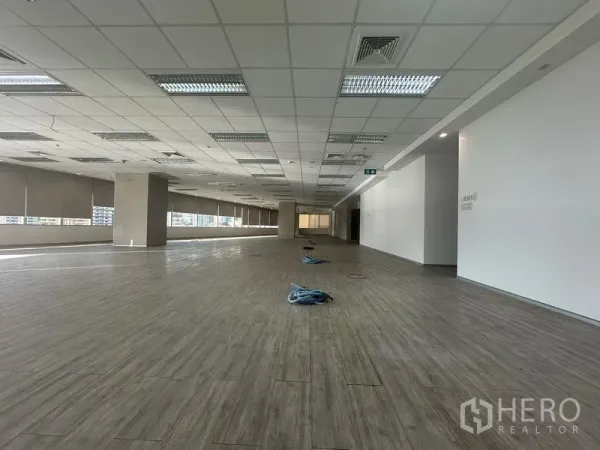 Office Space for rent in Khlong Toei, Bangkok - Expansive open-plan office floor with wood-look flooring, drop ceilings, and a long window line in Khlong Toei.