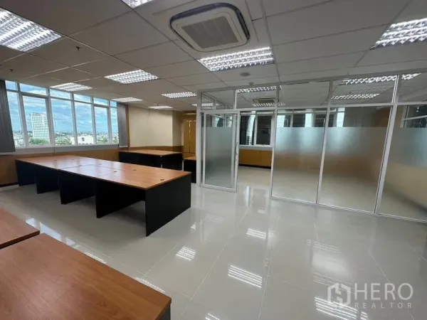 Office Space for rent in Suan Luang, Bangkok - Corner workspace with large windows and city views, wood desks, frosted-glass partitions and recessed AC.