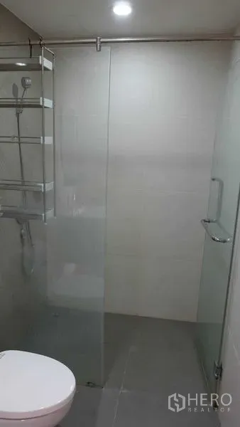 公寓 出租在Phaya Thai, Bangkok - 现代化浴室，玻璃淋浴间、置物架与坐便器，位于靠近BTS Ari的帕亚泰公寓。