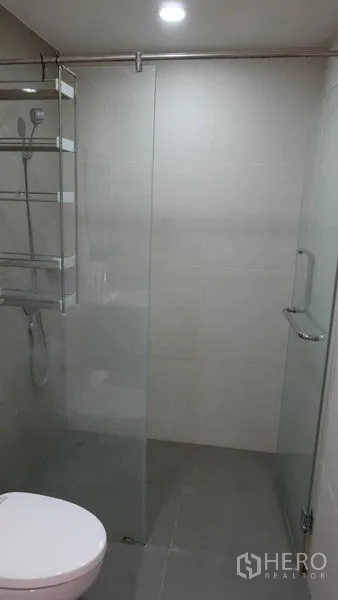 公寓 出租在Phaya Thai, Bangkok - 现代化浴室，玻璃淋浴间、置物架与坐便器，位于靠近BTS Ari的帕亚泰公寓。