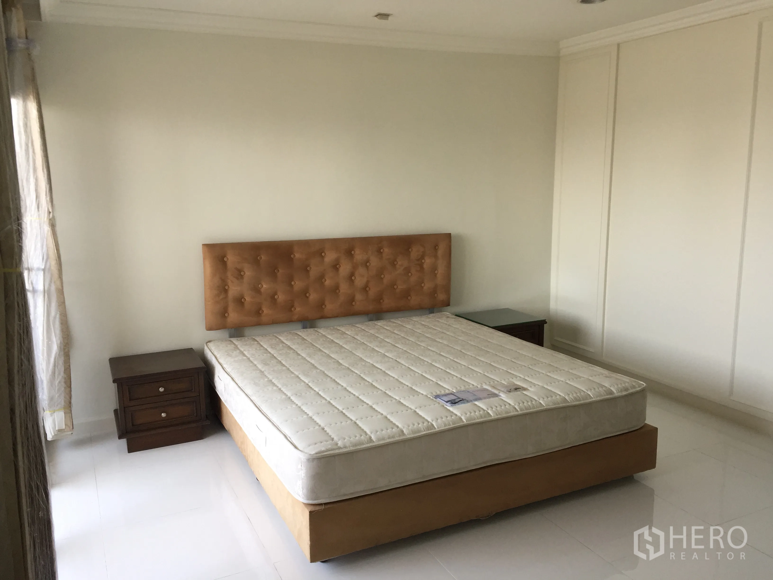 公寓 出租在Watthana, Bangkok - 采光良好的卧室，软包床头、床头柜与通顶衣柜墙。