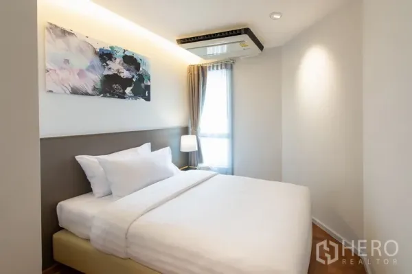 อพาร์ทเมนท์ ให้เช่าในYan Nawa, Bangkok - ห้องนอนรองพร้อมเตียงคู่ งานศิลปะ โคมไฟหัวเตียง และหน้าต่างพร้อมผ้าม่าน