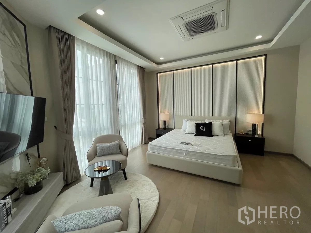 独立式住宅 出租在Lat Phrao, Bangkok - 主卧带大窗与休闲角，摆放大床