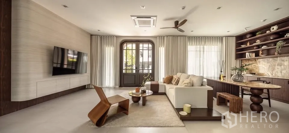 บ้านเดี่ยว for rent or sale in Lat Krabang, Bangkok - ห้องนั่งเล่นสว่างติดทีวี ผนังบิวท์อินและหน้าต่างสูง