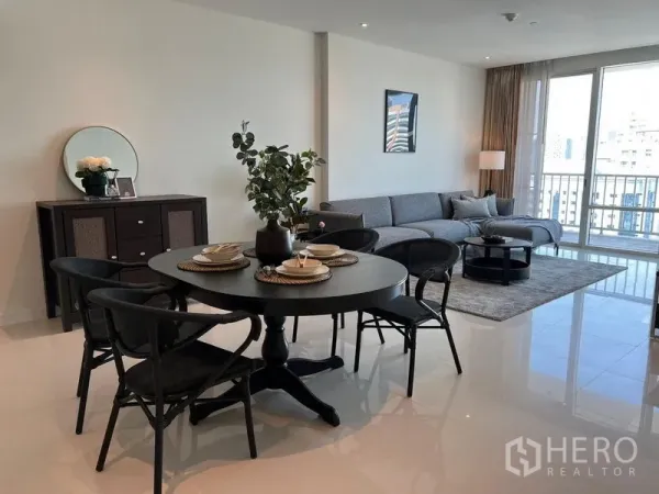คอนโด ให้เช่าในWatthana, Bangkok - ห้องนั่งเล่นและรับประทานอาหารแบบเปิดโล่ง โซฟาเทา โต๊ะอาหารสีดำ และหน้าต่างสูงจรดเพดานมองเห็นวิวเมือง