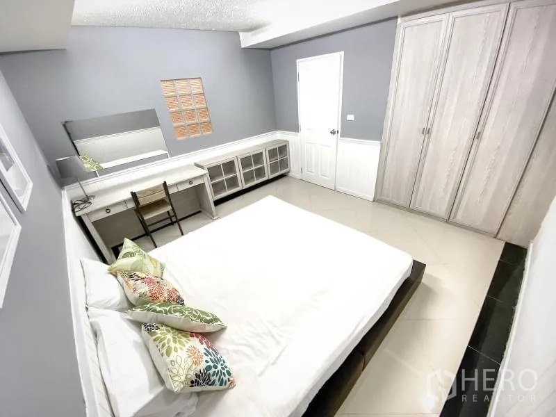 Condominium for rent in Khlong Toei, Bangkok - Second bedroom with bed, dressing table, long cabinet and double wardrobes.