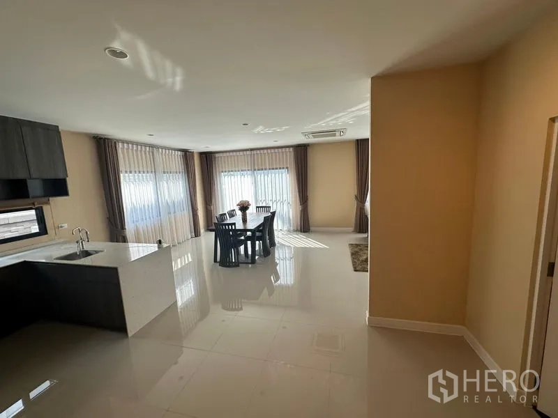 Detached House for rent or sale in Lam Luk Ka, Pathum Thani - Bright dining zone beside the pantry kitchen with floor-to-ceiling windows and glossy tiles.