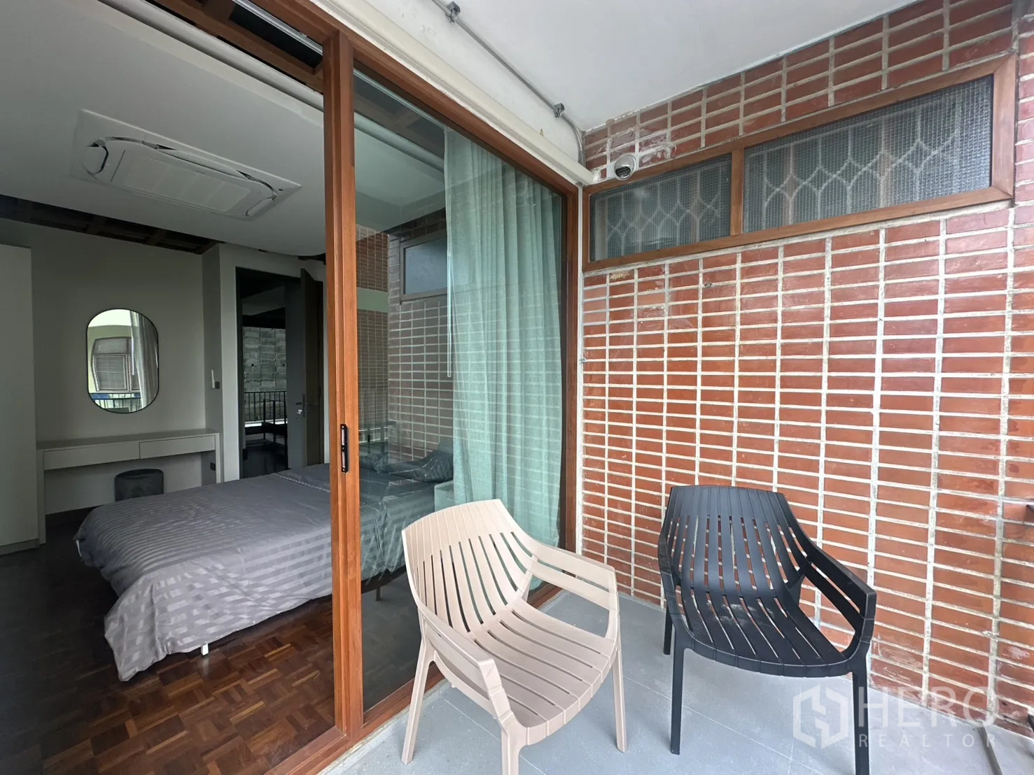 พื้นที่ขายของ for rent in Watthana, Bangkok - ระเบียงส่วนตัวหน้าห้องนอน ผนังอิฐและประตูกระจกบานเลื่อน.