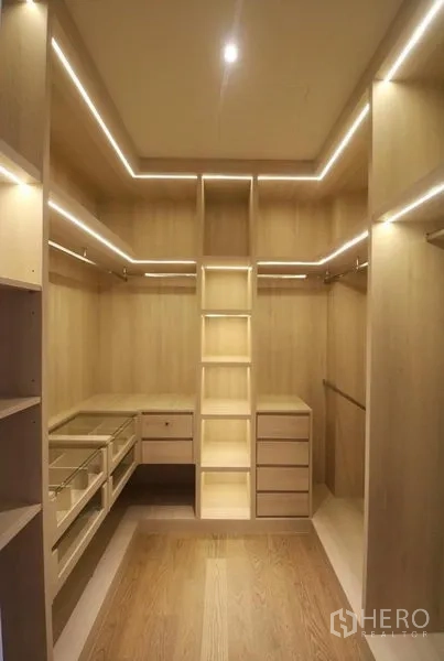 公寓 出租在Khlong San, Bangkok - 宽敞步入式衣帽间，浅木色柜体、抽屉与环形LED灯带。