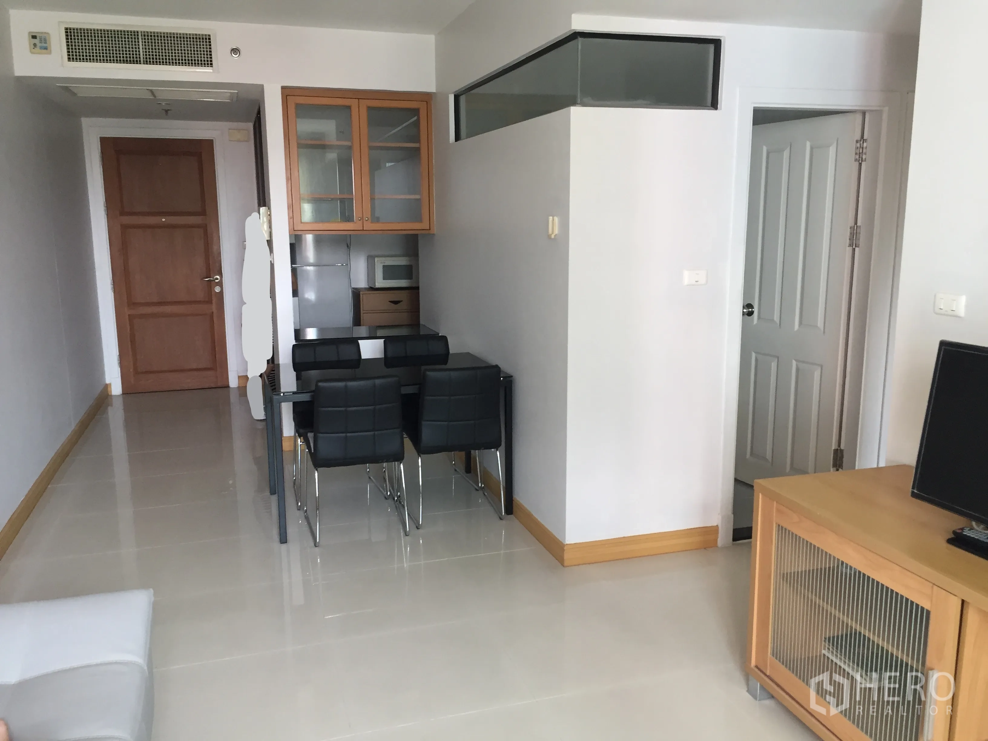 公寓 出租在Watthana, Bangkok - 明亮的客餐厅，瓷砖地面，黑色餐椅、电视柜与内置收纳柜。