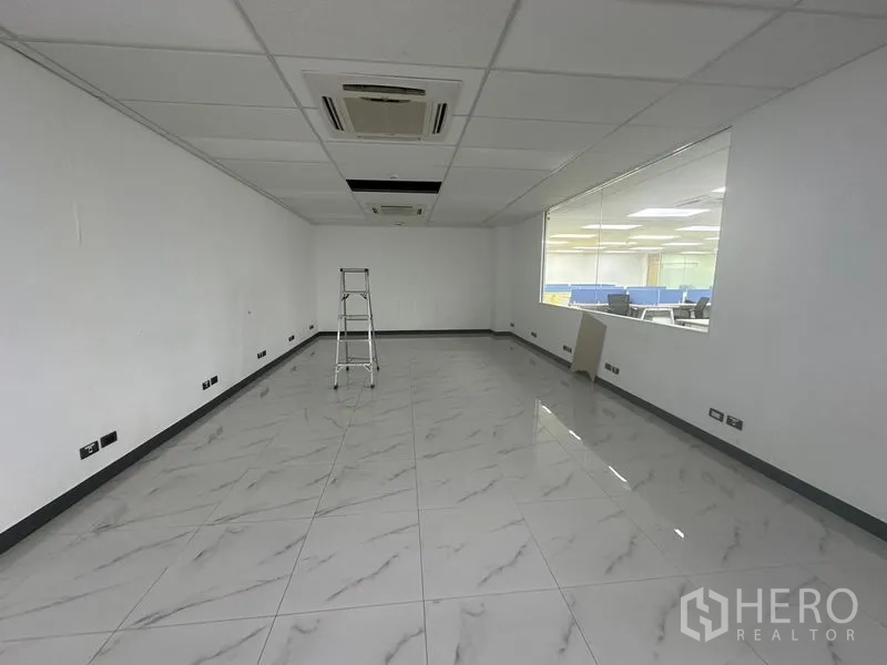Office Space for rent - Empty multipurpose room with marble-look tile flooring, drop ceiling and interior viewing window.