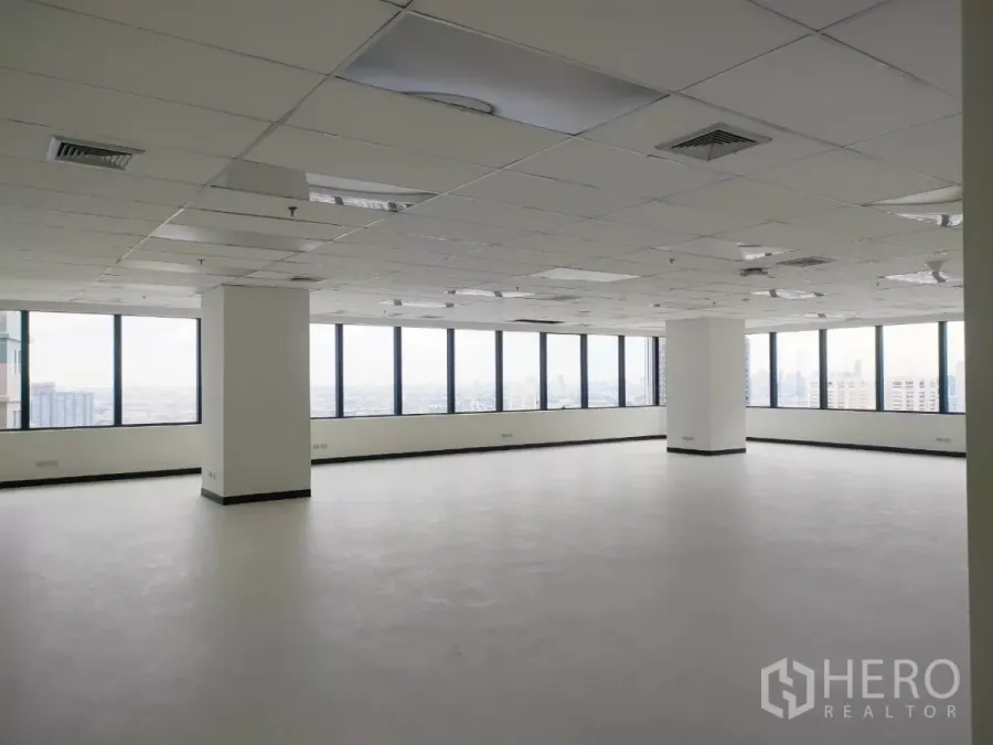Office Space for rent in Huai Khwang, Bangkok - Bright open‑plan office with large corner windows, city views, and a suspended ceiling with lighting and air vents.