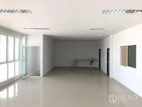 Factory for rent or sale in Bang Sao Thong, Samut Prakan - Bright office space with large windows, tiled flooring, and a pantry sink.