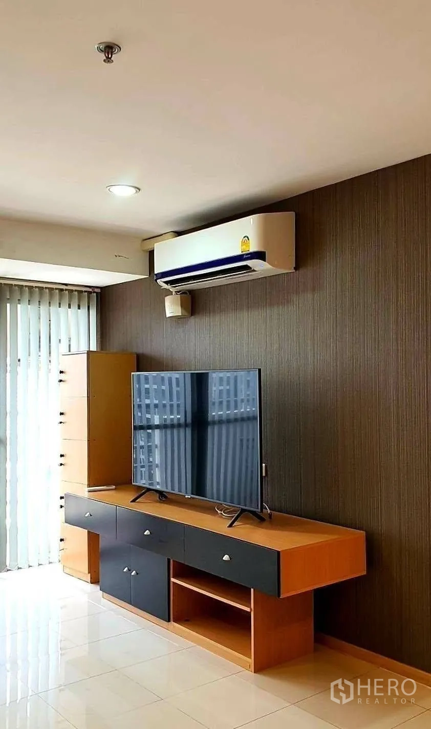 公寓 for rent in Khlong Toei, Bangkok - 客厅一角有电视柜、壁挂空调与竖百叶。