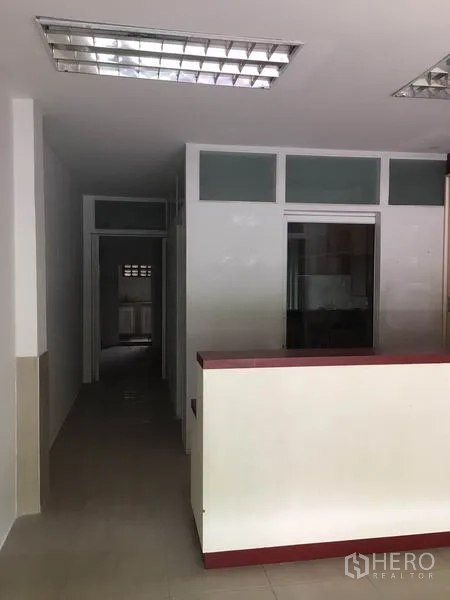 Shophouse for rent in Khlong Toei, Bangkok - Partitioned ground-floor workspace with fluorescent lighting and a front counter.