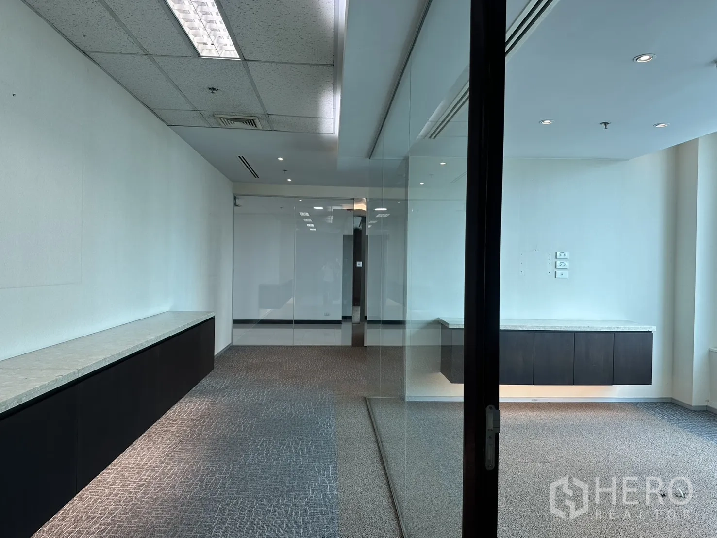 Office Space for rent in Watthana, Bangkok - Glass-walled meeting room and open workspace with carpet tiles and recessed lights.