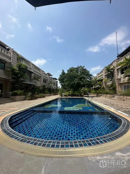 ทาวน์เฮาส์ ให้เช่าในKhlong Toei, Bangkok - สระว่ายน้ำส่วนกลางกระเบื้องสีน้ำเงิน ระหว่างแถวทาวน์เฮ้าส์ ใต้ท้องฟ้าแจ่มใสย่านอ่อนนุช