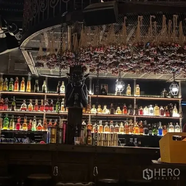 Retail Space for rent in Watthana, Bangkok - Dimly lit bar interior with illuminated liquor bottle shelves and decorative ceiling feature.
