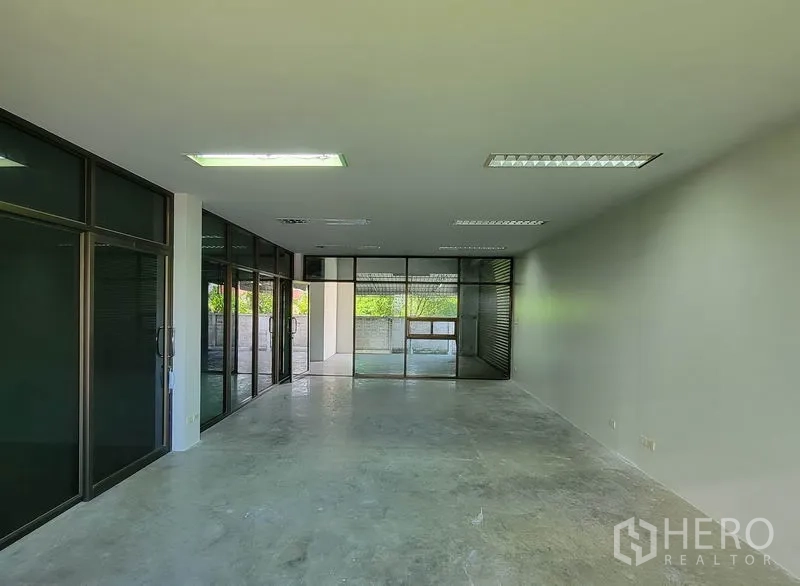 Warehouse for rent in Sam Phran, Nakhon Pathom - Open-plan office with glass walls leading to a covered yard.