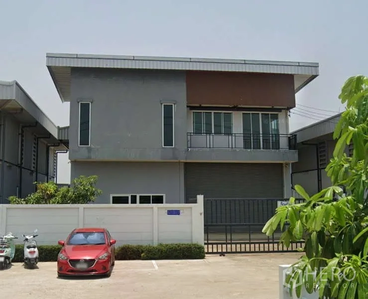 Factory for rent or sale in Ban Phaeo, Samut Sakhon - Front elevation of the industrial building showing the upper office windows and main shutter door