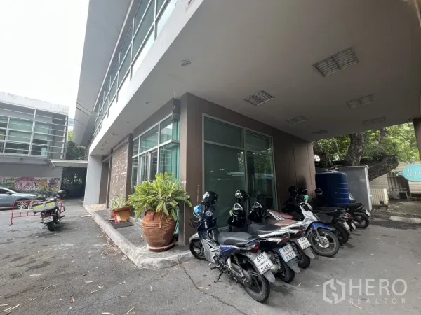 สำนักงาน ให้เช่าในWatthana, Bangkok - มุมอาคารกระจกโอบรอบ กระถางต้นไม้และที่จอดมอเตอร์ไซค์ในร่ม