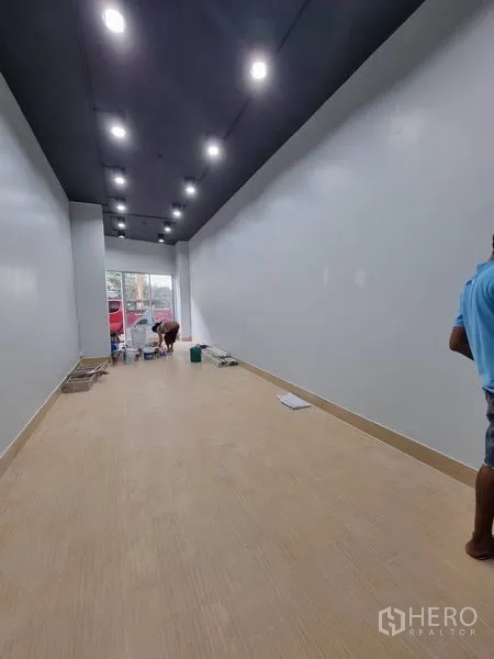 Retail Space for rent in Khlong Toei, Bangkok - Long shop interior with light wood flooring, recessed lighting and front window facing the street.