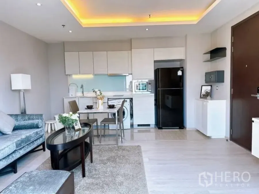 Condominium for rent in Watthana, Bangkok - Open-plan living with fitted kitchen, washer and fridge plus a compact dining set.