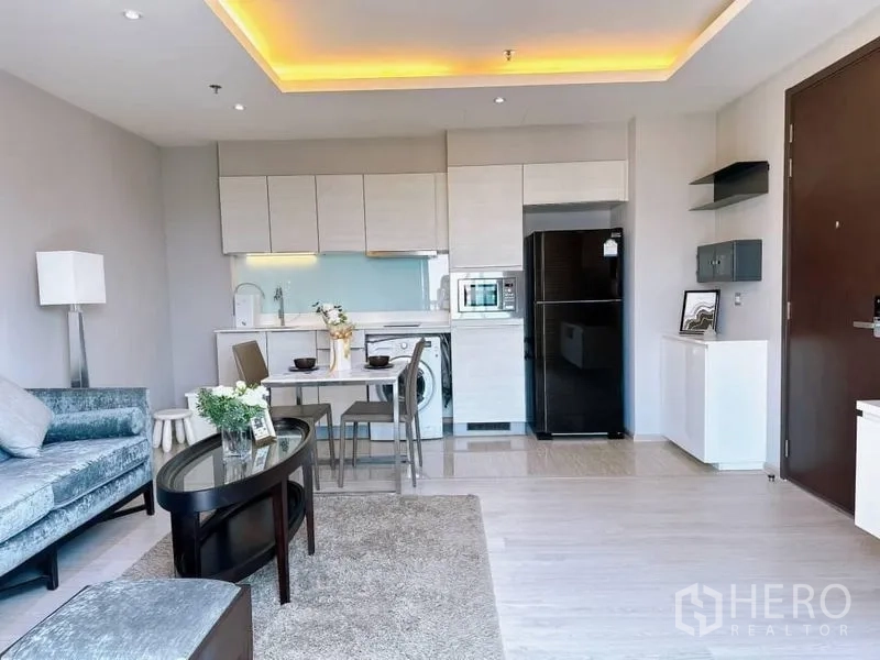 Condominium for rent in Watthana, Bangkok - Open-plan living with fitted kitchen, washer and fridge plus a compact dining set.