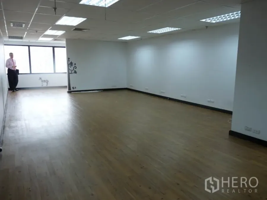 Office Space for sale in Watthana, Bangkok - Long open-plan room with white walls, wood floors and windows providing natural light.