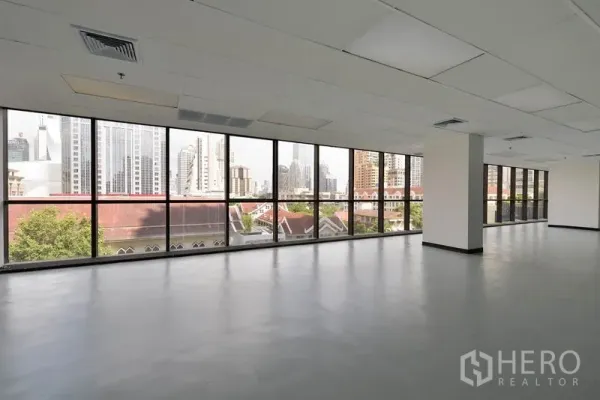 Office Space for rent in Pathum Wan, Bangkok - Corner open‑plan office floor with full-height windows and Bangkok skyline views.