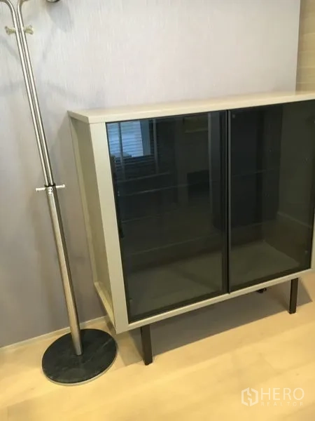 Detached House for rent in Wang Thonglang, Bangkok - Compact glass-front cabinet beside a metal coat stand on light wood flooring.