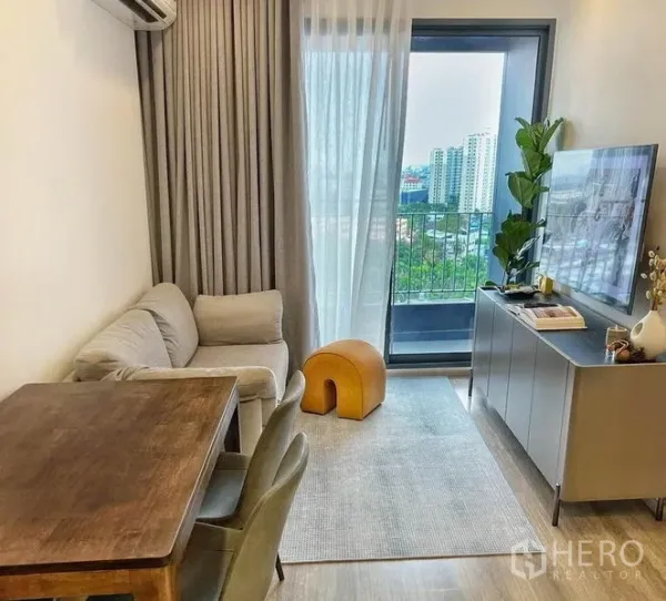 Condominium for rent or sale in Bang Na, Bangkok - Living and dining area opening to a balcony with city views near BTS Udom Suk.