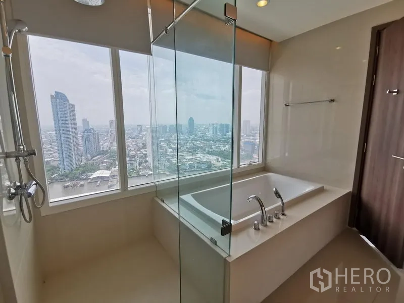 คอนโด ให้เช่าในBang Kho Laem, Bangkok - ห้องน้ำพร้อมฝักบัวกระจกและอ่างอาบน้ำ มองเห็นวิวเมืองและแม่น้ำกว้าง